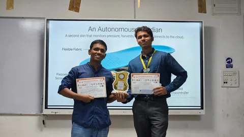 Participants holding certificates and a trophy after a project presentation.