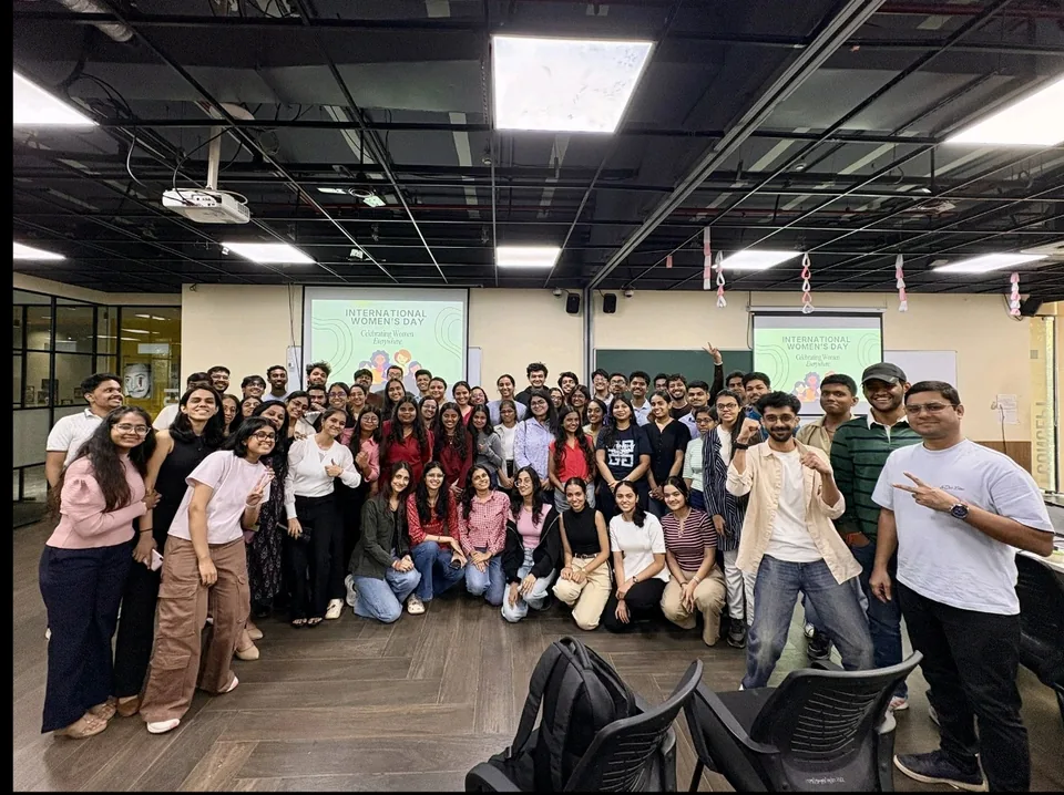 Shubham Sahu with Lovable × Anthropic Buildathon participants in front of International Women’s Day screens